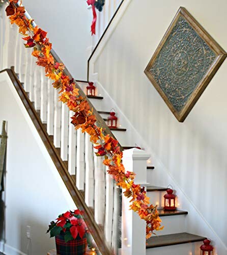 Staircase decorated with autumn leaves garland and lanterns.