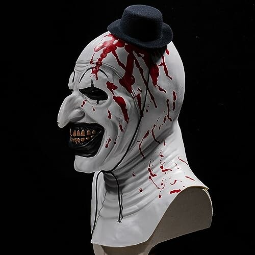 Side view of a creepy clown mask with blood and small hat