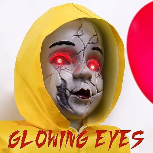 Creepy doll with glowing red eyes in a yellow hooded outfit.