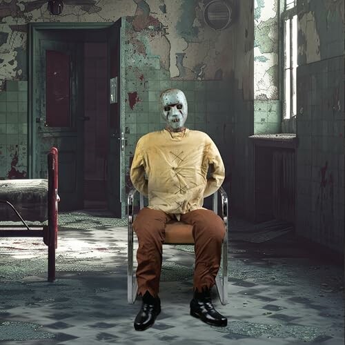 Figure in a mask and straitjacket sitting in an abandoned room.