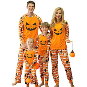 Family wearing matching Halloween pumpkin pajamas.