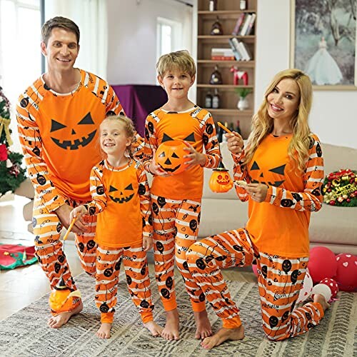 Family in matching Halloween-themed pajamas holding pumpkin decorations.