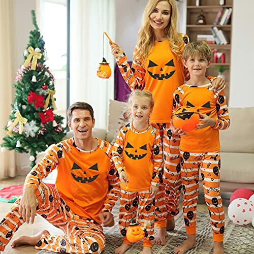 Family in matching Halloween pajamas by a Christmas tree.