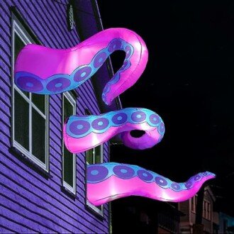 Giant inflatable tentacles emerging from a house window at night.