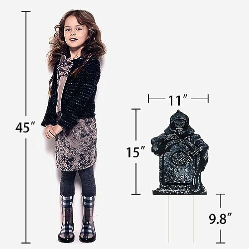 Girl standing next to a Halloween tombstone decoration.