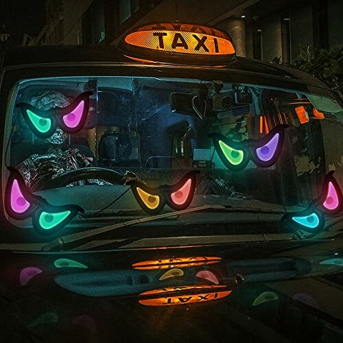 Taxi windshield with glowing eyes stickers at night