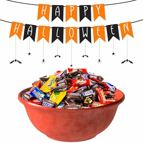 Bowl of assorted Halloween candy with festive banner.