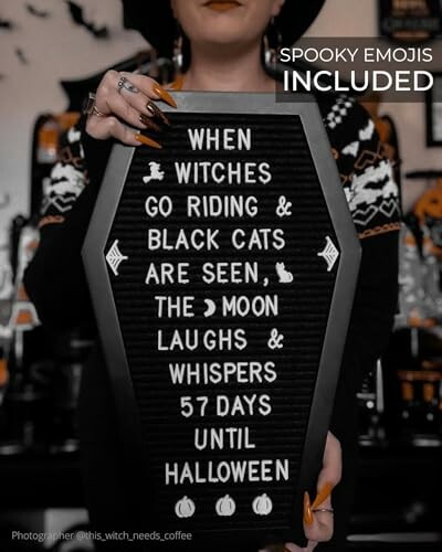 Person holding a coffin-shaped sign with a Halloween countdown message.