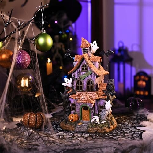 Halloween haunted house decoration with ghosts and pumpkins.