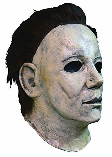 Side view of a Halloween mask with dark hair and blank eyes.