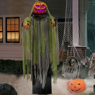 Halloween pumpkin-headed figure with green cloak and glowing face.