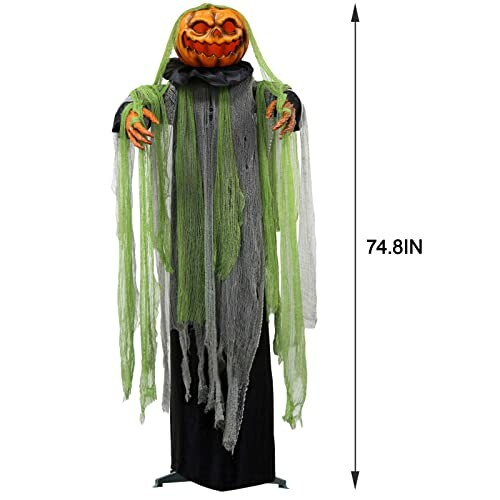 Tall Halloween scarecrow with a pumpkin head and green drapes.