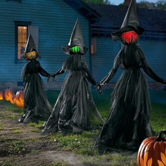 Three pumpkin-headed figures in black robes and witch hats holding hands.