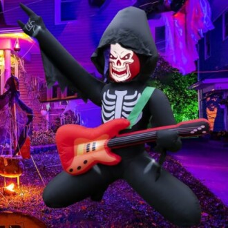 Inflatable skeleton figure playing guitar at Halloween display