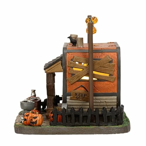 Halloween-themed miniature house decoration with pumpkins and spooky details.