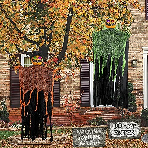 Halloween decorations with pumpkin heads and spooky signs in a yard.