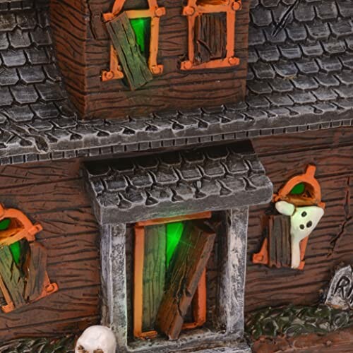 Halloween haunted house decoration with boarded windows and green lights