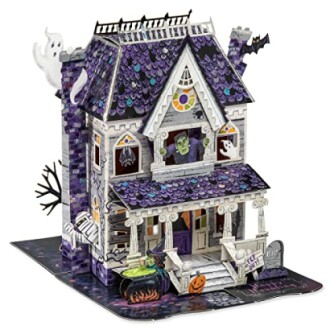 Pop-up Halloween card with a haunted house design featuring ghosts, bats, and a Frankenstein figure.