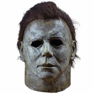 Horror movie character mask with dark hair and hollow eyes.