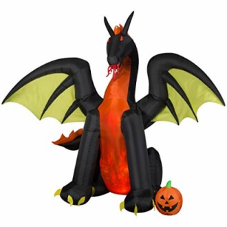 Inflatable dragon with wings and a pumpkin for Halloween.