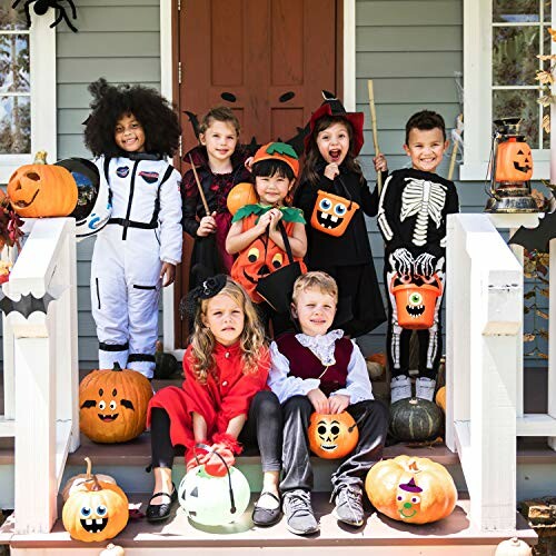 Children in Halloween costumes on a porch with pumpkins.