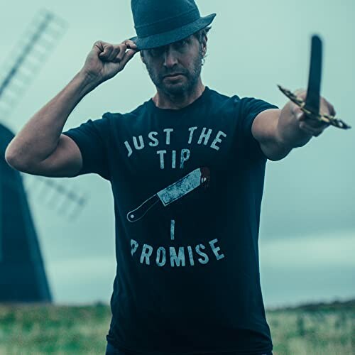 Man wearing a hat holding a sword with text 'Just the Tip I Promise' on shirt.