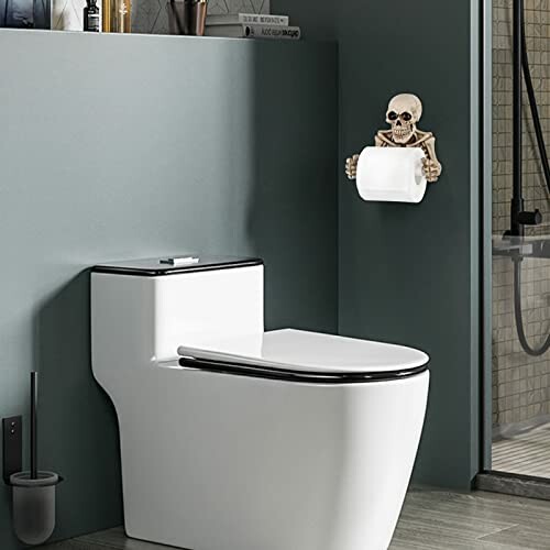 Modern bathroom with toilet and skull toilet paper holder.