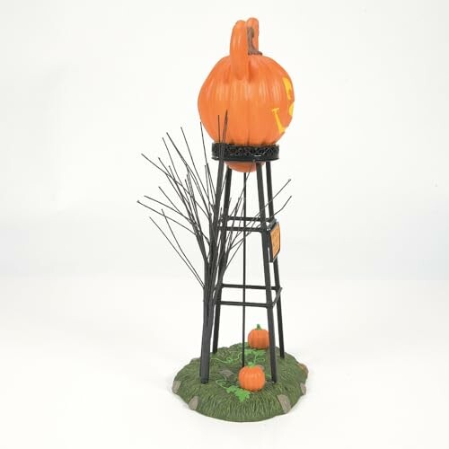 Pumpkin-themed water tower decoration with pumpkins and bare tree.