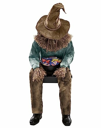 Scarecrow figure holding candy in lap.