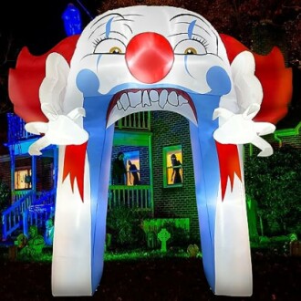 Inflatable clown archway with a spooky design in front of a house.