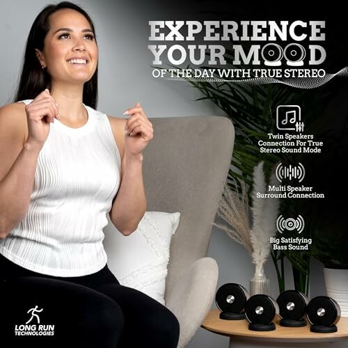 Woman enjoying music with a stereo speaker system on a table.