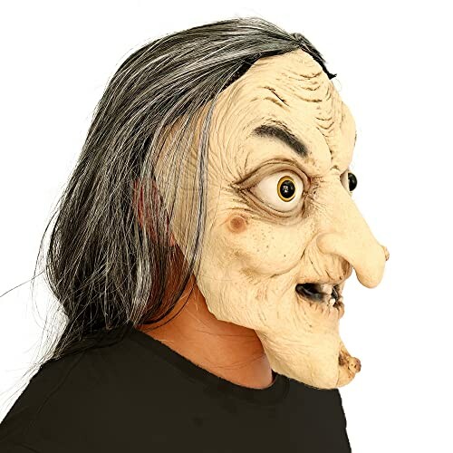 Side view of a person wearing a witch mask with long hair and exaggerated features.