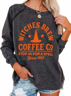 Woman wearing a dark sweatshirt with 'Witches Brew Coffee Co' design.